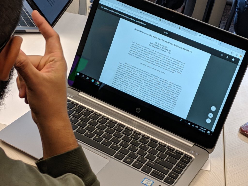 Student reading article on laptop
